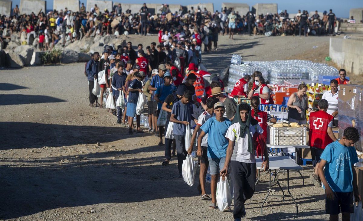 La Policía usa gas lacrimógeno durante el reparto de alimentos a los migrantes en la playa ceutí del Trampolín